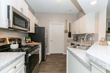 Kennesaw apartment for rent - A kitchen with a black stove top oven and a black refrigerator.