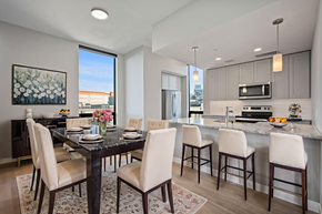 Denver apartment for rent - A modern dining room with a black table and white chairs.