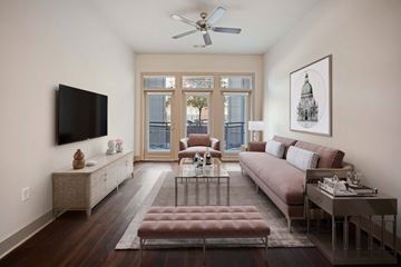 Denver apartment for rent - A living room with a brown couch and a television on the wall.
