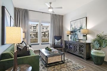 The Colony apartment for rent - an apartment living room with a green couch and a window