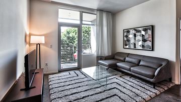 Los Angeles apartment for rent - a living room with a couch and a glass coffee table