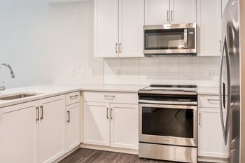 Classic apartment homes feature gourmet kitchens with quartz counters and tiled backsplashes