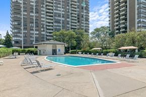 Southfield apartment for rent - A swimming pool surrounded by lounge chairs in a residential area.