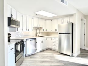 Aurora apartment for rent - A modern kitchen with white cabinets and stainless steel appliances.