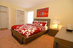 Indianapolis apartment for rent - A bedroom with a large bed and a red and white comforter.