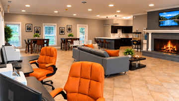 Indianapolis apartment for rent - A modern living room with orange chairs and a fireplace.