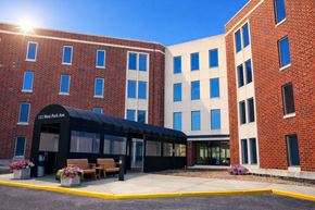 Aurora apartment for rent - A sunny day at the 11 West Ave building entrance.
