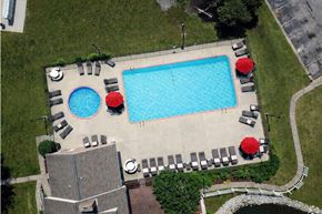 Indianapolis apartment for rent - A pool surrounded by chairs and umbrellas.