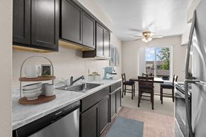 Southfield apartment for rent - A kitchen with black cabinets and a marble countertop.