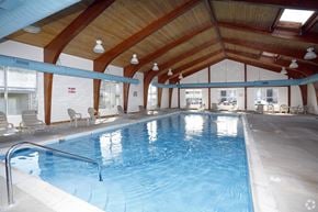 Indianapolis apartment for rent - A large indoor swimming pool with a wooden ceiling and white walls.