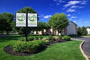 Indianapolis apartment for rent - Two signs reading "The Park at Greenhill" stand in front of a building.
