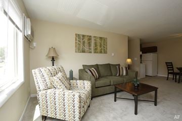 Urbana apartment for rent - A living room with a patterned chair and a couch.