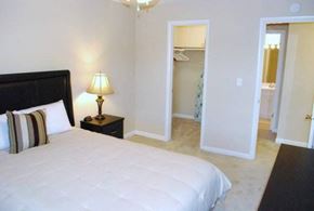 Urbana apartment for rent - A bedroom with a large bed and a lamp on a side table.