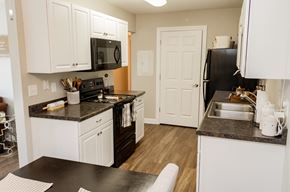 Urbana apartment for rent - A kitchen with white cabinets and black appliances.