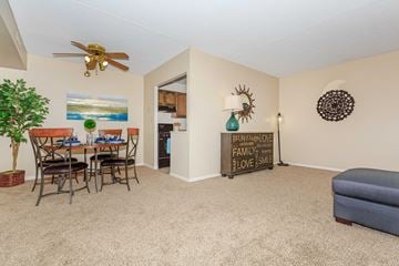 Cuyahoga Falls apartment for rent - A living room with a dining table and chairs, a sofa, and a ceiling fan.