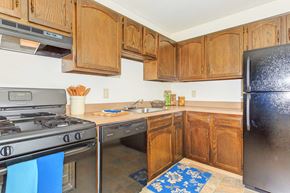 Cuyahoga Falls apartment for rent - A kitchen with wooden cabinets and a black refrigerator.