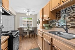 South Lyon apartment for rent - A kitchen with wooden cabinets and a black stove top oven.