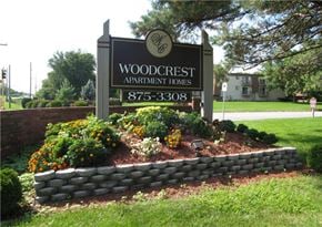 Decatur apartment for rent - A sign for Woodcrest Apartment Homes is in front of a building.