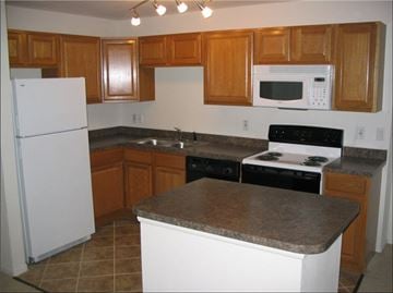 Decatur apartment for rent - A kitchen with a white refrigerator and a black stove top oven.