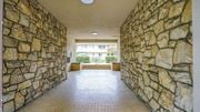 Pasadena apartment for rent - A long hallway with stone walls and a tiled floor.