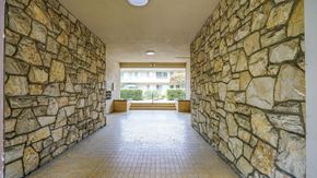Pasadena apartment for rent - A long hallway with stone walls and a tiled floor.