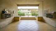 Pasadena apartment for rent - A hallway with a tiled floor and a view of a building through a window.
