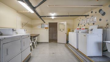 Pasadena apartment for rent - A clean, empty industrial kitchen with white appliances and a yellow line on the floor.