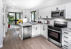 Omaha apartment for rent - a kitchen with white cabinets and stainless steel appliances