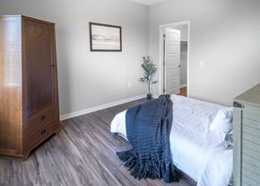 Lincoln apartment for rent - A bedroom with a bed, a dresser, and a painting on the wall.