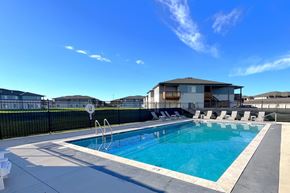North Platte apartment for rent - a swimming pool with chairs around it in front of a house