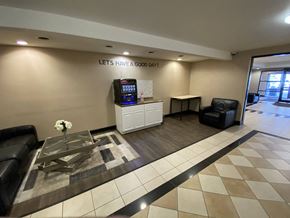 Des Moines apartment for rent - Lobby of 3000 Grand community, featuring a table, chairs, and a TV.