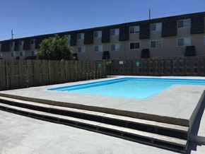 Topeka apartment for rent - A refreshing swimming pool surrounded by lounge chairs at Cedar Ridge Apartments.