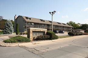 Omaha apartment for rent - The entrance sign of Eden West Apartments, positioned at the main entrance with lush greenery in the background.