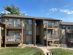 Omaha apartment for rent - Exterior apartment building at Fox Run Apartments featuring balconies, entrances, and landscaped grounds.