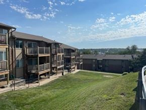 Omaha apartment for rent - Exterior view of Fox Run Apartments buildings with open green space and landscaped community grounds.