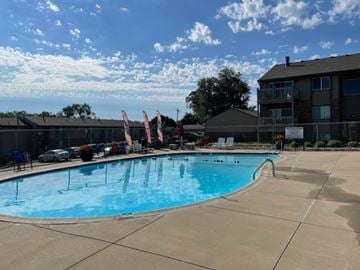 Omaha apartment for rent - A large swimming pool with a concrete floor and a concrete sidewalk.