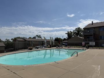 Omaha apartment for rent - A large swimming pool with a slide and a building in the background.