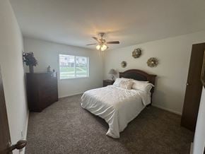Lawrence townhouse for rent - A bedroom in a Park 25 Apartments model unit, featuring a bed and a ceiling fan, creating a comfortable and relaxing space.