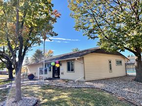 Omaha apartment for rent - The clubhouse at Cambridge Apartments, a tan building with balloons decorating the main entrance and yard.