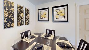 West Des Moines apartment for rent - Dining room in a Regency Woods model unit with a wooden table set for four.