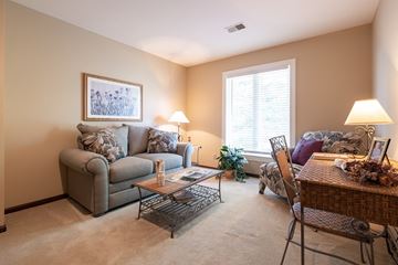 Overland Park apartment for rent - A living room with a grey couch, a coffee table, and a painting on the wall.