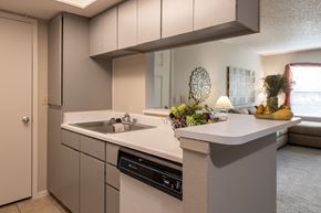 Kansas City apartment for rent - Cozy kitchen featuring wooden cabinetry, a sink, and ample counter space, perfect for home cooking.