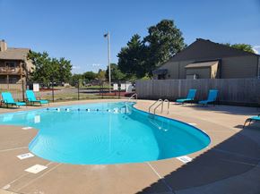 Wichita apartment for rent - A swimming pool surrounded by lounge chairs, offers a relaxing environment at Willow Creek Apartments.