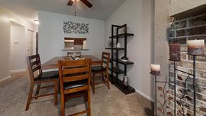 Liberty apartment for rent - Cozy dining area with a wooden table, matching chairs, and soft lighting, creating a welcoming atmosphere for meals.