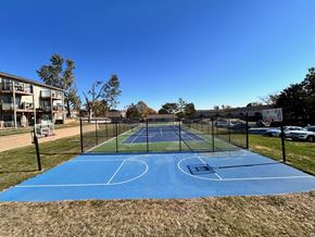 Omaha apartment for rent - Fenced blue basketball court at Cambridge Apartments, tennis court located behind.