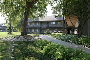 Omaha apartment for rent - A building at Eden West Apartments with a tree and a sidewalk in front of it.