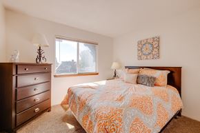 West Des Moines apartment for rent - Bedroom in the two-bedroom model unit at Olde English Village, featuring a comfortable bed and soft lighting.