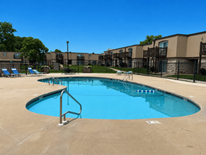 Lawrence townhouse for rent - Swimming pool at Park 25 Apartments on a sunny day surrounded by lounge chairs and apartment buildings.
