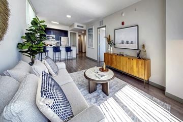 Miami apartment for rent - A living room with a grey couch and a wooden cabinet.