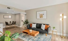 Phoenix apartment for rent - A living room with a grey couch, a wooden coffee table, and a painting on the wall.